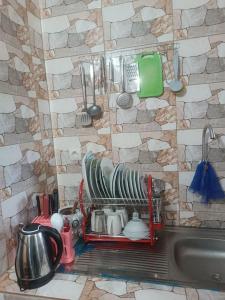 una cocina con fregadero y un estante con platos en Résidence Meublée Smart 2, en Man