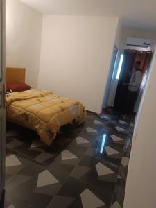 Un dormitorio con una cama y suelo de baldosas. en Résidence Meublée Smart 2, en Man