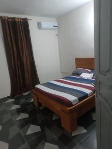 Cama en habitación con suelo a cuadros en Résidence Meublée Smart 2, en Man 16 fotos más