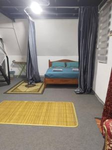 Kaki BukitにあるNour Homestay - Rumah Aのベッドルーム1室(ベッド1台付)、床に敷物2枚が備わります。
