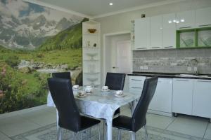 a kitchen with a table with chairs and a mountain mural at Zara in Bishkek