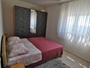 ein Schlafzimmer mit einem Bett, einem Spiegel und einem Fenster in der Unterkunft Apartment Nera ST - Two-Bedroom Apartment with Sea View in Omiš