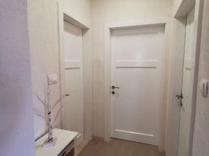 einen Flur mit einer weißen Tür und einer Vase auf dem Tisch in der Unterkunft Apartment Nera ST - Two-Bedroom Apartment with Sea View in Omiš + 11 Fotos