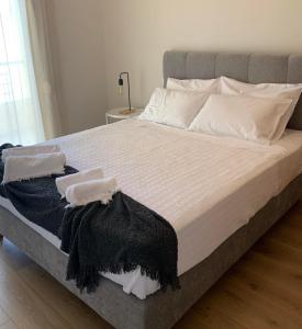 a large bed with black and white sheets and pillows at Adeste to Ioannina Apartment in Ioannina