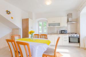 a kitchen with a table with a vase of flowers on it at Apartment Magdalena - Three Bedroom Apartment in Nerežišća