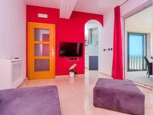 a living room with a red wall and a door at Apartments Villa Bella Vista - Two Bedroom Apartment with Balcony and Sea View in Potomje