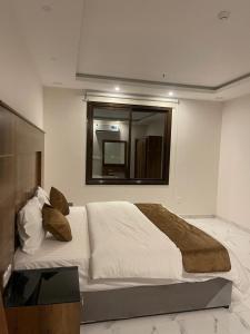 a bedroom with a large bed and a mirror at منازلكم للشقق المخدومة in Al Mikhlaf +4 photos