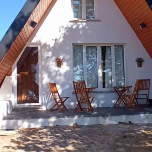 ein Haus mit Schaukelstühlen auf der Veranda in der Unterkunft Chalé Zimbro, Serra da Estrela, Penhas da Saúde in Penhas da Saúde