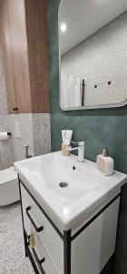 a bathroom with a white sink and a mirror at LUX-Апартаменты Manhattan style на Тохтарова in Ustʼ-Kamenogorsk