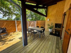 a wooden deck with a table and chairs on it at Maison de vacances familiale in Le Teich