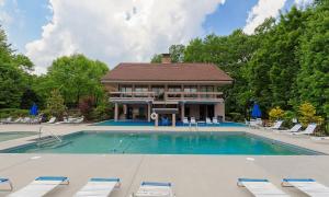a large swimming pool with chairs and a house at Smoky Mountain Skies in Gatlinburg