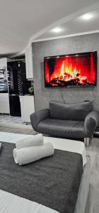 Una sala de estar con un sofá y una chimenea. en LUX-Апартаменты New York style на Чехова, en Öskemen