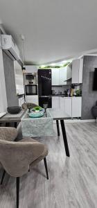 Una sala de estar con una mesa y una cocina. en LUX-Апартаменты New York style на Чехова, en Öskemen 19 fotos más