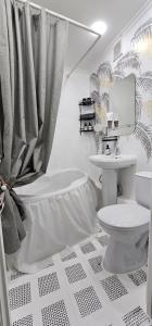 Un baño blanco con inodoro y lavabo. en LUX-Апартаменты New York style на Чехова, en Öskemen