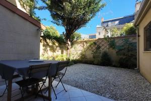 a patio with a table and chairs in a courtyard at Havre de paix 6 pers Bordeaux Chartrons in Bordeaux