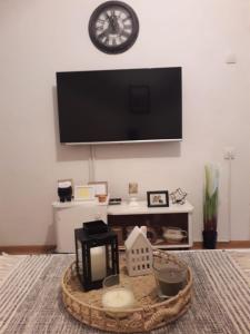 a living room with a tv on a wall with a table at Apartman Tanja Trebinje in Hrupjela