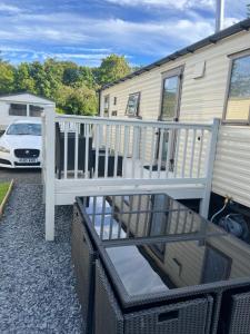 a deck with a white railing next to a house at 75 Lakeside East Haggerston Castle play passes not included in Cheswick