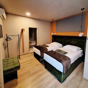 ein Hotelzimmer mit zwei Betten und einem Stuhl in der Unterkunft Boutique Hotel St Georgije in Banja Luka + 33 Fotos