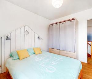a bedroom with a large bed with two pillows on it at Maison typique royannaise dans un quartier calme in Royan