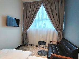 Kampong Sungai PutatAustin Melaka的卧室在窗户前配有沙发