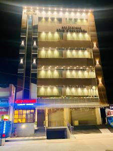 un edificio alto con luces encima en PPH Living Gnr Grand Luxury Rooms, en Madanapalle