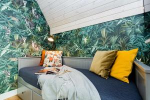 a bedroom with a bed with colorful pillows at Žalia kopa with pool in Palanga +40 photos