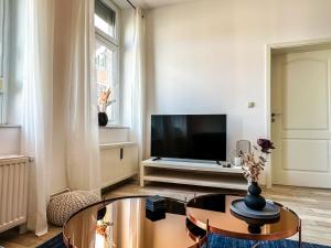 ヴォルフスブルクにあるR und S Apartments Stylische Wohnung I Küche I Parkplatz I Smart TVのテレビとテーブルのあるリビングルーム