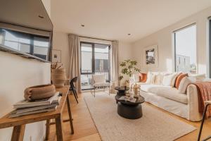 un salon avec un canapé blanc et une table dans l'établissement Chic and Contemporary Living at Cambridge Terrace, à Christchurch