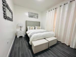 Un dormitorio blanco con una cama y una ventana. en casamia luxury apartments, en Nairobi 6 fotos más