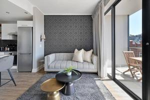 a living room with a couch and a table at Bella - Stylish 1-Bed Apt in trendy De Waterkant with Balcony in Cape Town