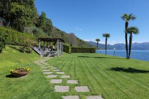 a grassy field with a pathway next to the water at Yachting Residence in Ghiffa
