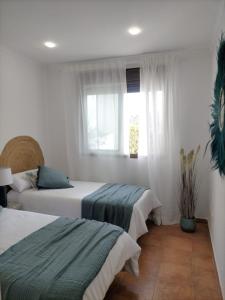 ein Schlafzimmer mit zwei Betten und einem Fenster in der Unterkunft Vera La Hermosa in Vera