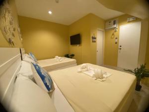 a hotel room with two beds with towels on them at Glory Inn and Suites Boracay in Boracay
