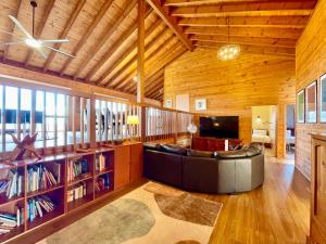 a large living room with a couch and a tv at Treetops Retreat Katoomba in Katoomba