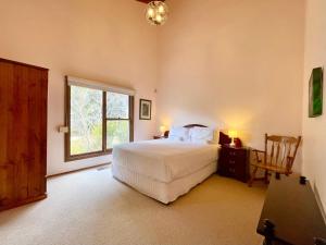 a bedroom with a white bed and a window at Treetops Retreat Katoomba in Katoomba +111 photos