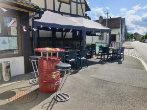a bar with stools in front of a restaurant at La Vieille Fermette in Obersaasheim