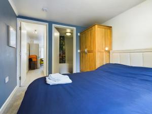 TilehurstにあるLovely 1 bedroom apartment with parkingのベッドルーム1室(青いベッド1台、木製キャビネット付)