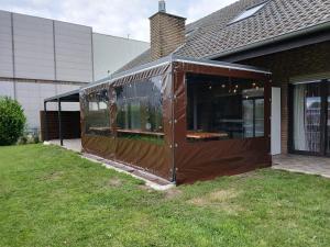 an enclosed greenhouse in front of a house at Hani's Partyhaus in Verl