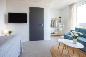 a living room with a blue couch and a tv at Hygge Homes - Cube Apartment in Borstel