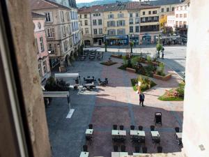 a person standing in a courtyard with tables and chairs at Hotel La Basilique in Épinal