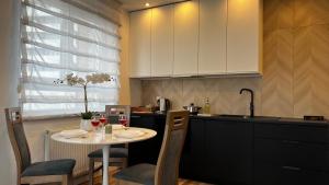 a kitchen with a small table with two glasses of wine at ParkCity Katowice in Katowice