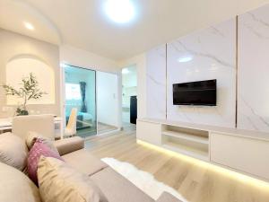 a living room with a couch and a tv at Joyful Room Poppular Condo P1 in Ban Song Hong +7 photos