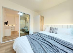 a bedroom with a large white bed and a mirror at Joyful Room Poppular Condo P1 in Ban Song Hong