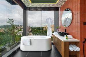 a bathroom with a white bath tub and a window at Kudos-My Downtown Hotel in Udaipur