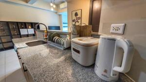 马尼拉EG Private House -BGC UPTOWN的厨房配有带水槽和门廊的台面