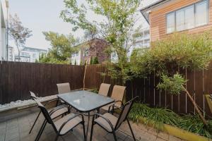 une table et des chaises sur une terrasse avec une clôture dans l'établissement Quaint Worcester Quarters - 3BR Delight, à Christchurch