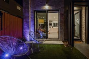 クライストチャーチにあるThe Coolest Townhouse in Christchurchの夜、庭に置かれた紫色の椅子2脚