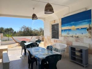 un patio con tavoli e sedie e un camino di Villa Antonietta By Cala Salento a Punta Prosciutto