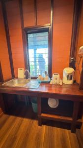 Una encimera de cocina con un fregadero y una ventana. en Cheriya bungalow Kohyaonoi, en Ban Laem Sai