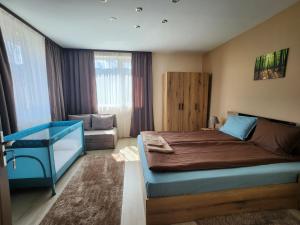 a bedroom with a bed and a chair in it at Къща за гости ЕВА in Madzhare